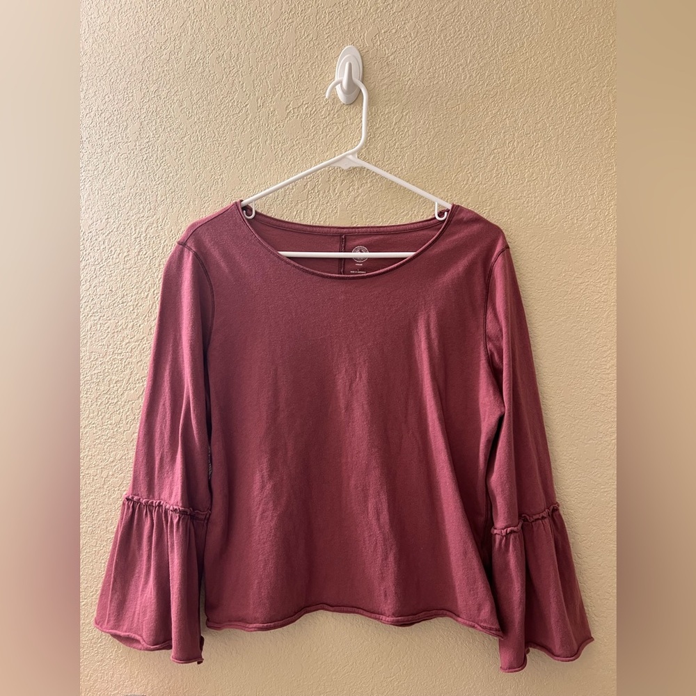 Burgundy shirt with ruffle sleeves.